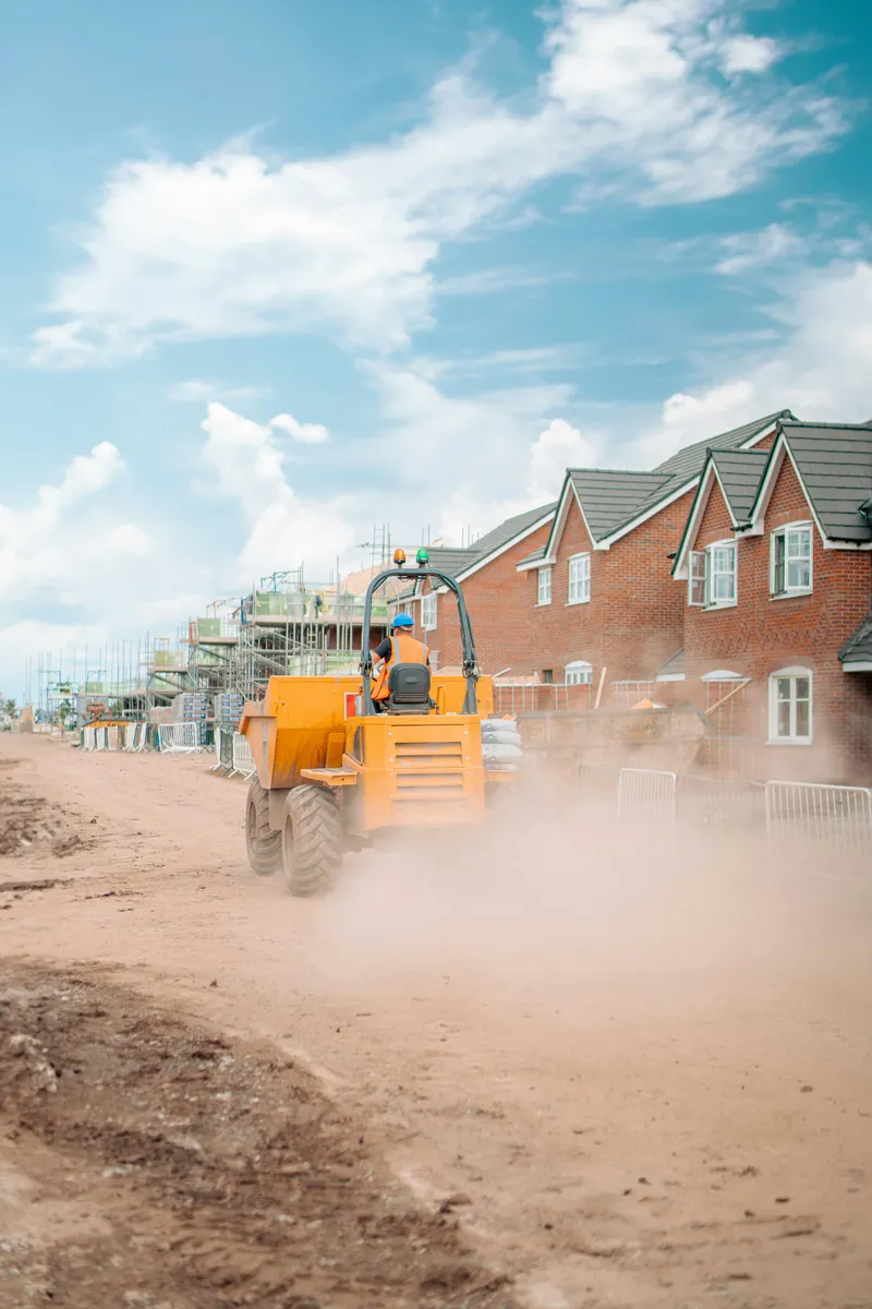 Construction site with dumper truck and new build houses